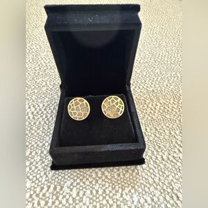 Gold studs with gemstones in the background